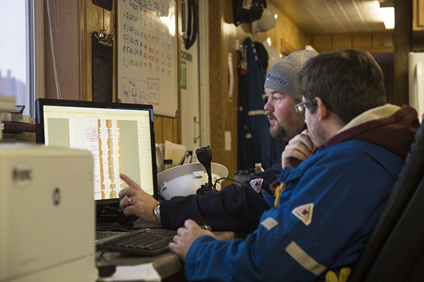 EERC employees pointing at a computer screen