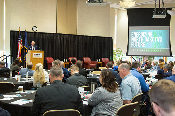 EERC CEO stands at podium addressing audience members.