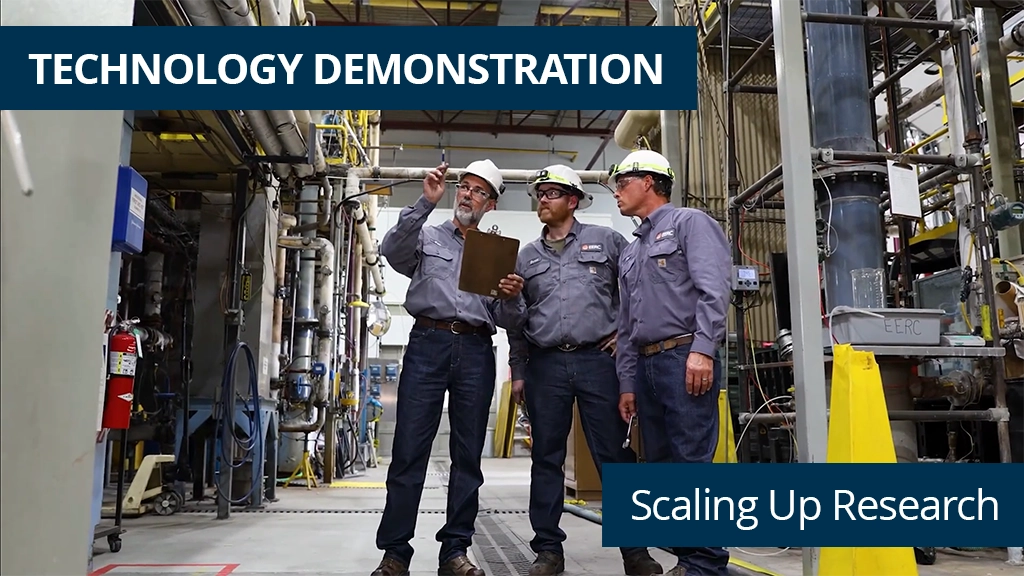 Three men in hard hats, working in a large facility